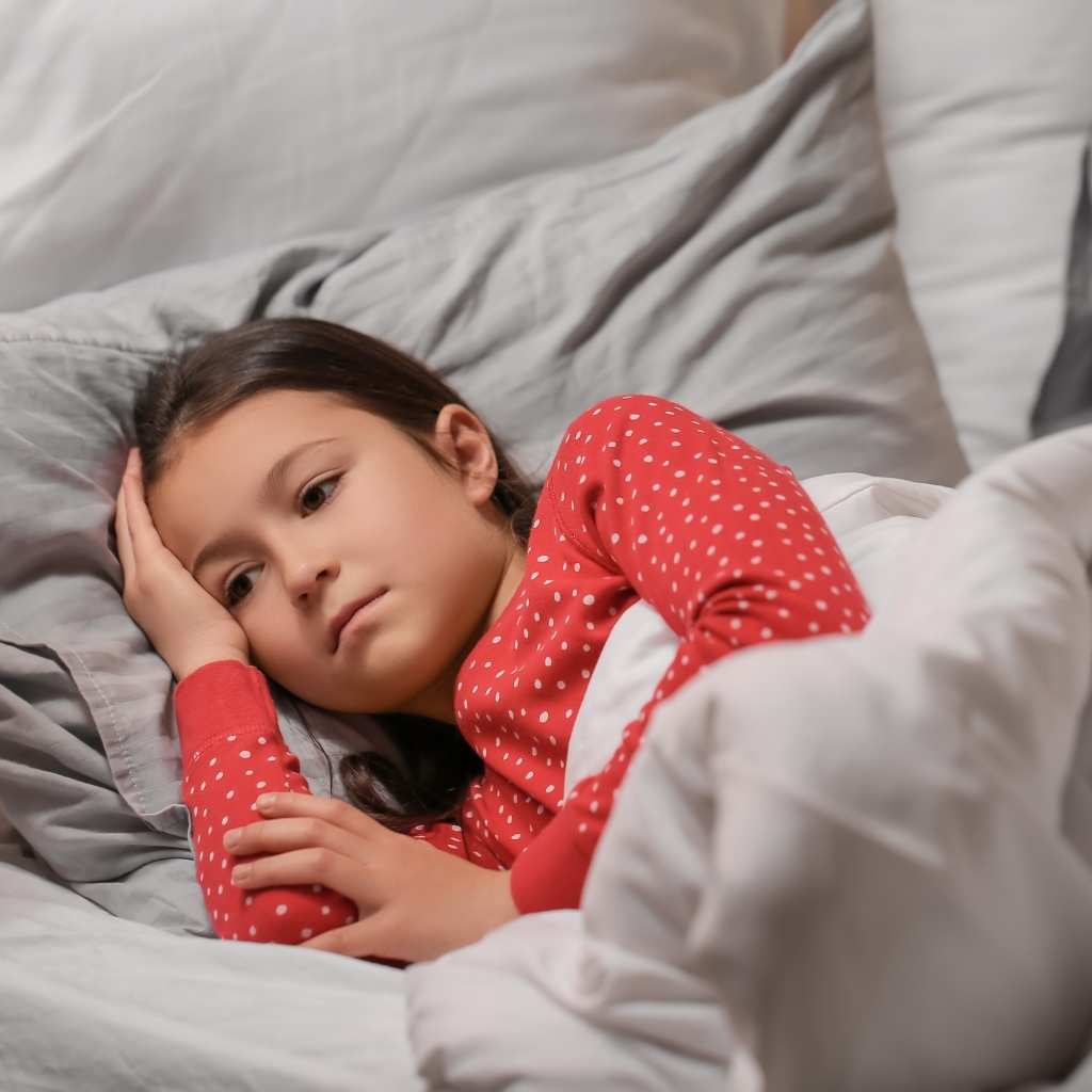 A child in pajamas unable to fall asleep, visually highlighting autism co-occurring conditions like a sleep disorder.