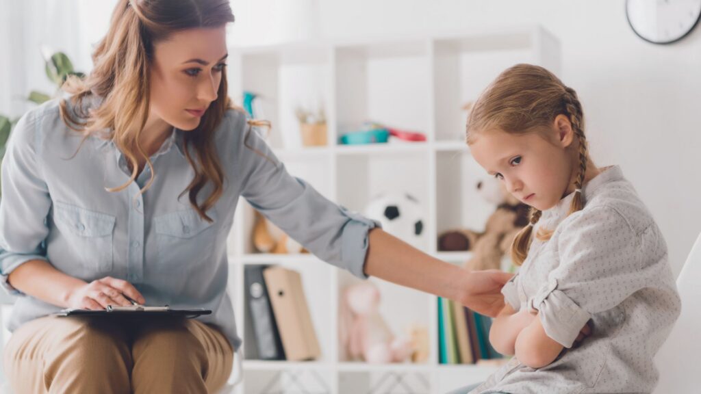 Therapist supporting a young child during an autism levels assessment in a calm therapy setting.