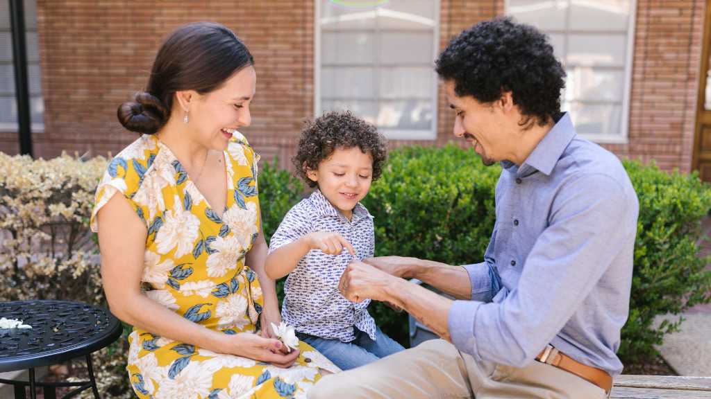 Smiling parents engaging with their child outdoors—representing the evidence-based benefits of parent training in aba for autism support.