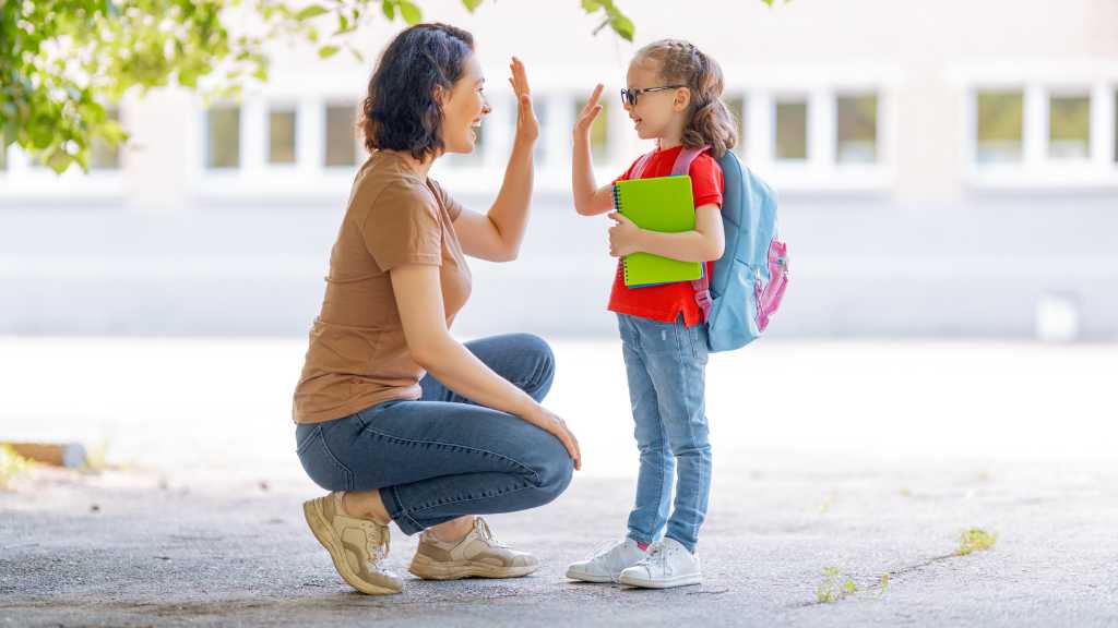 Caregiver high-fiving child after an autism diagnosis